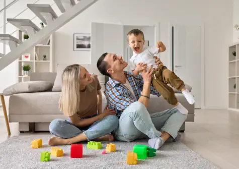 Family with baby playing in living room
